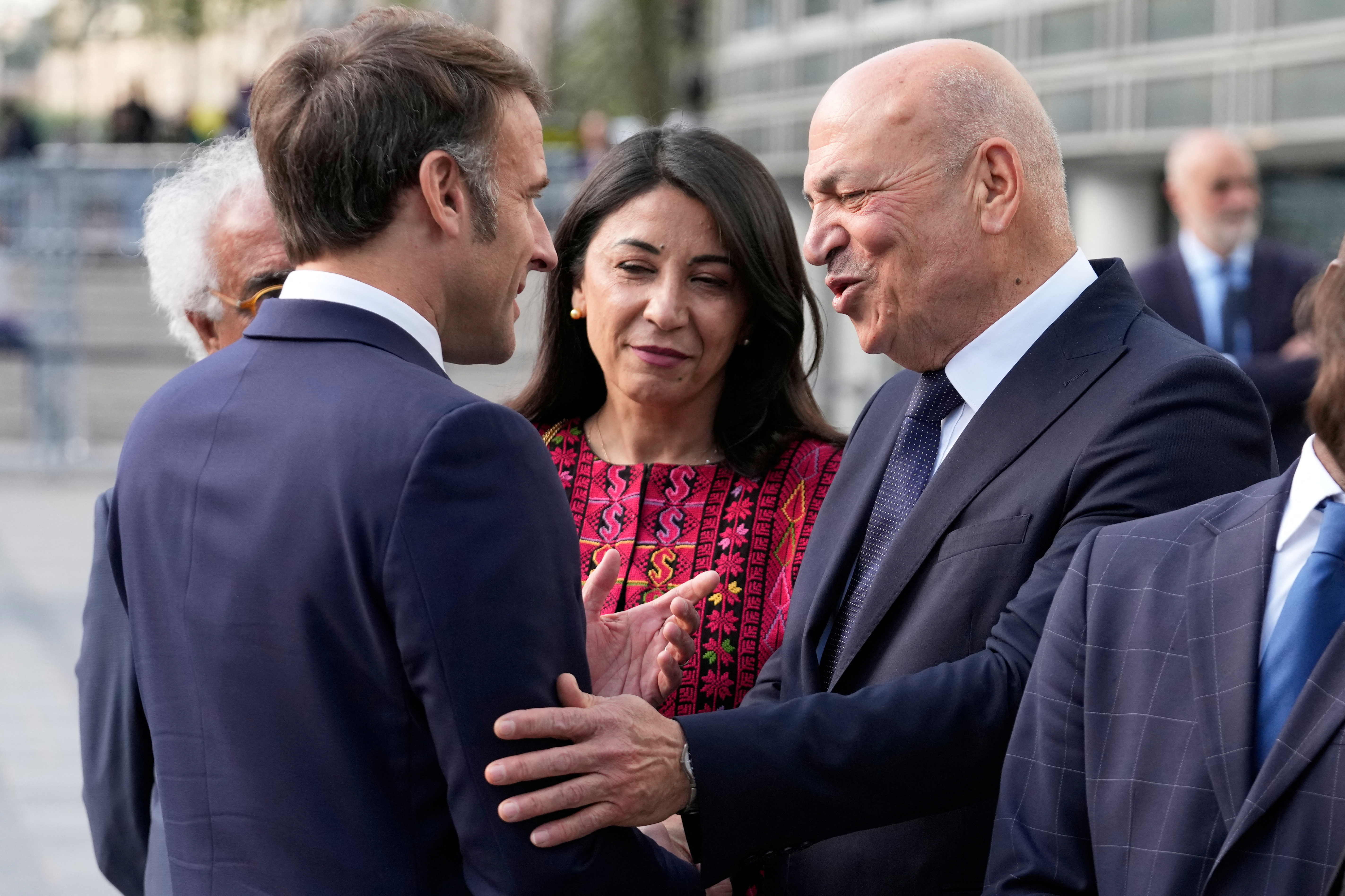 French President Emmanuel Macron, shakes hands with Hani al-Hayek, the Palestinian Authority's minister for heritage and tourism, before visiting the exhibition 