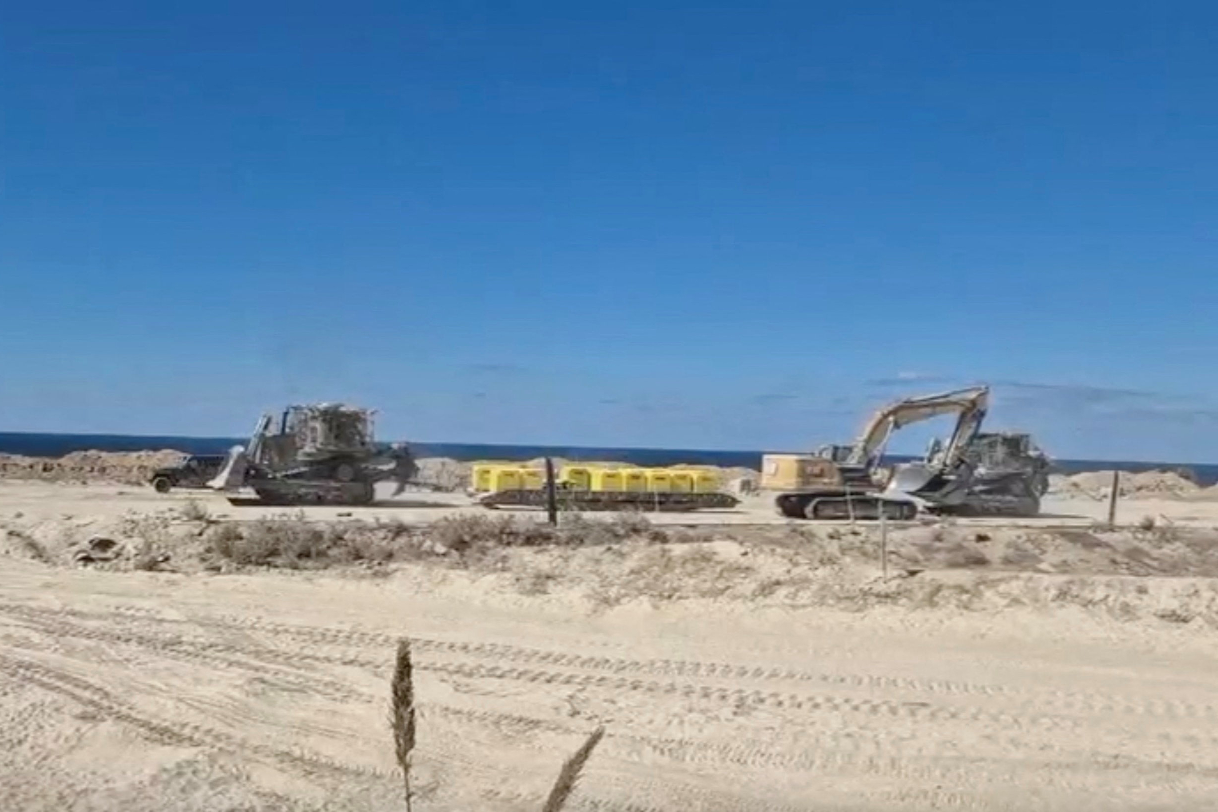 A screengrab from a handout video shows Israeli military vehicles moving barrier blocks to mark the 