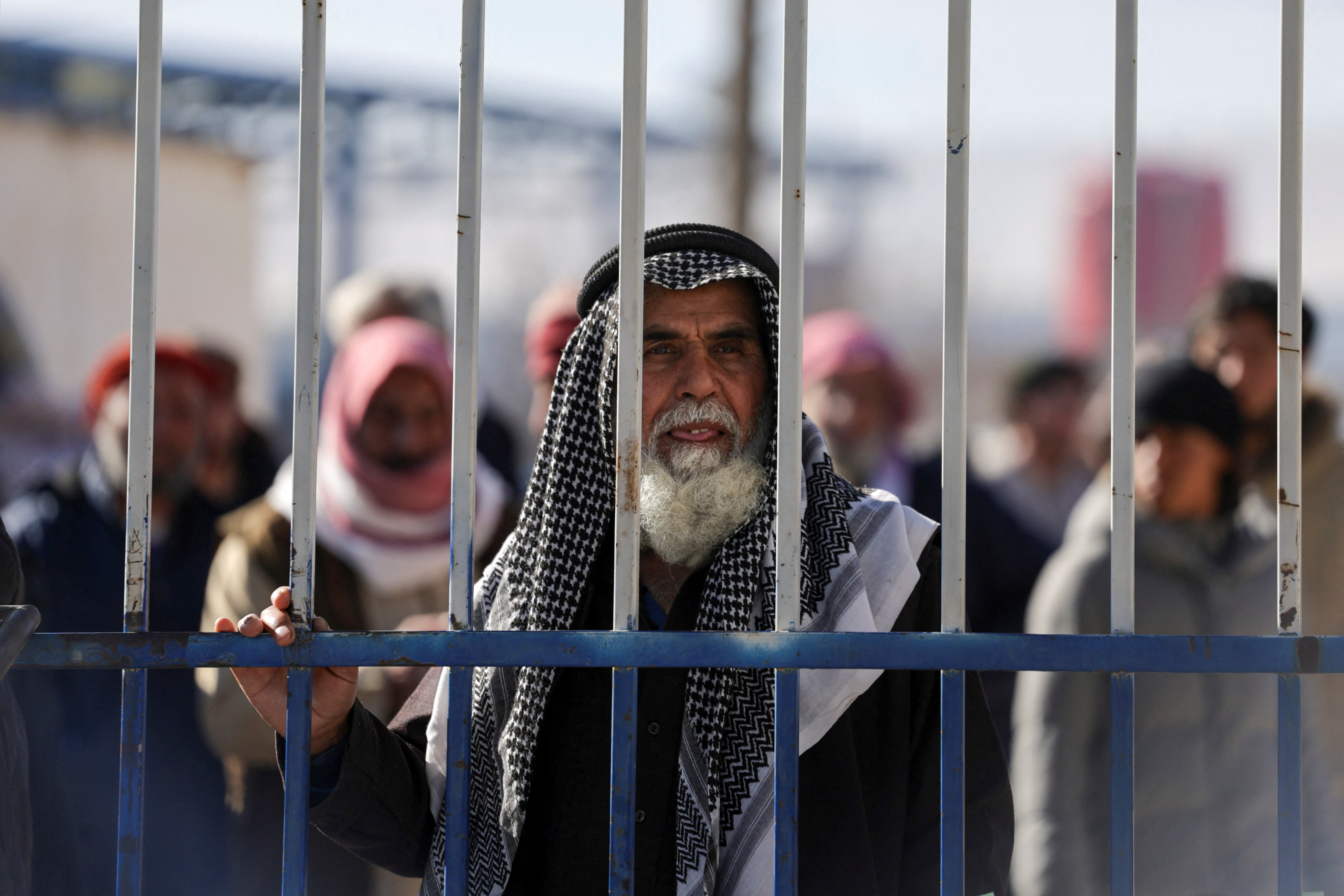 A detainee looks through a gate at al-Hol camp after the Syrian government took control of it following the withdrawal of Syrian Democratic Forces (SDF), in Hasaka, Syria, January 21, 2026. Photo: Reuters Connect by Khalil Ashawi